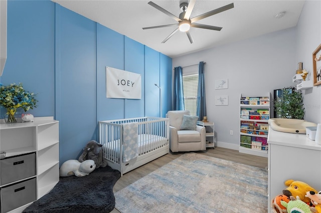 17676 Passionflower Cir, Clermont, FL 34714 - bedroom with a crib, light wood-style flooring, and a ceiling fan