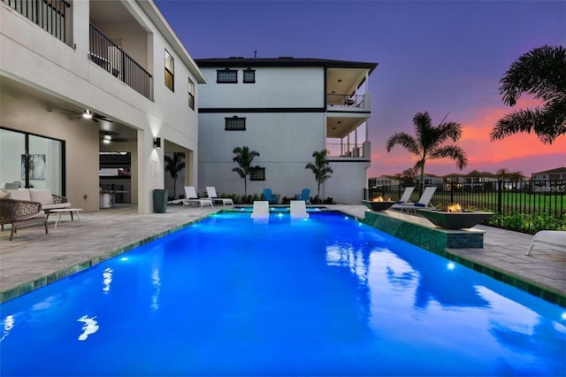 1526 Euston Dr, Reunion, FL 34747 - pool at dusk featuring a patio, ceiling fan, and an outdoor hangout area