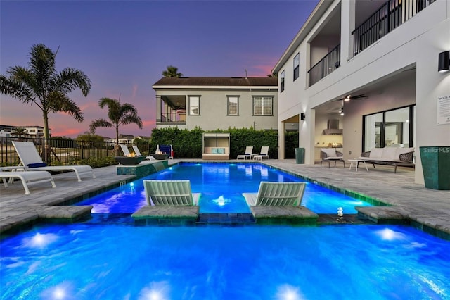 1526 Euston Dr, Reunion, FL 34747 - pool at dusk featuring an outdoor living space, a pool with connected hot tub, ceiling fan, and a patio area