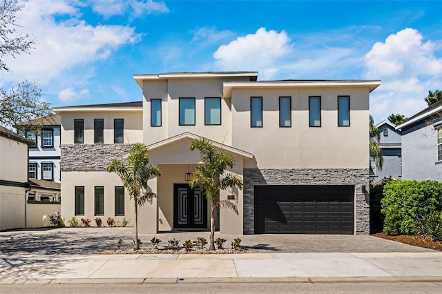 1526 Euston Dr, Reunion, FL 34747 - contemporary house with stone siding, stucco siding, a garage, and driveway