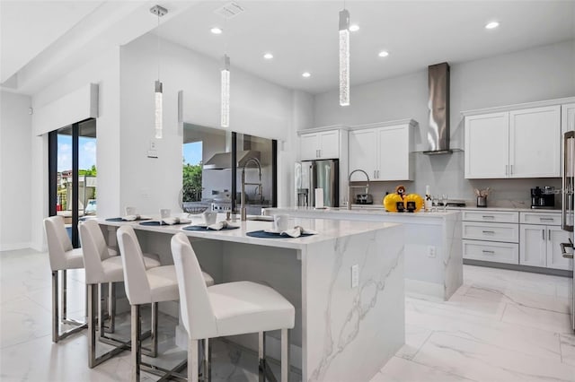 1526 Euston Dr, Reunion, FL 34747 - kitchen featuring wall chimney exhaust hood, a center island with sink, light marble finish floors, stainless steel fridge, and recessed lighting