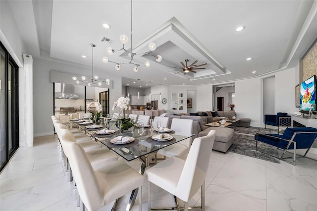 1526 Euston Dr, Reunion, FL 34747 - dining area featuring a tray ceiling, a ceiling fan, a chandelier, and recessed lighting