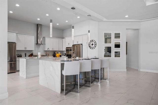 1526 Euston Dr, Reunion, FL 34747 - kitchen featuring wall chimney range hood, stainless steel appliances, a large island, light marble finish flooring, and a breakfast bar area