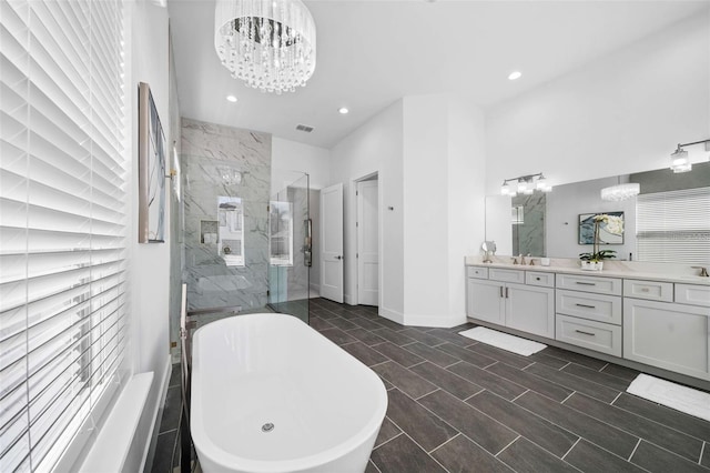 1526 Euston Dr, Reunion, FL 34747 - full bathroom with a chandelier, a marble finish shower, a soaking tub, vanity, and recessed lighting