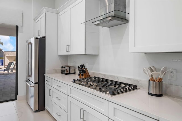 1526 Euston Dr, Reunion, FL 34747 - kitchen with appliances with stainless steel finishes, white cabinets, wall chimney exhaust hood, and light stone countertops