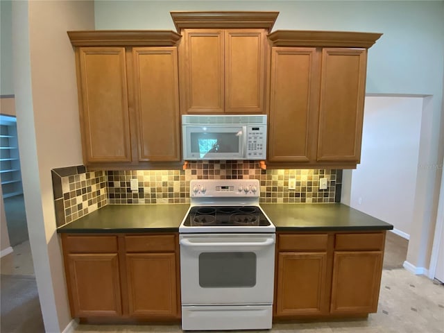 1227 Juniper Hammock St, Winter Garden, FL 34787 - kitchen with white appliances, decorative backsplash, dark countertops, and brown cabinetry