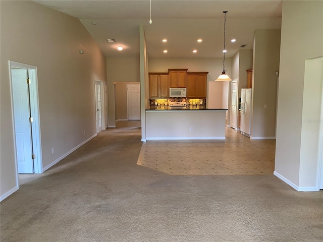 1227 Juniper Hammock St, Winter Garden, FL 34787 - kitchen with white appliances, dark countertops, open floor plan, light carpet, and a high ceiling