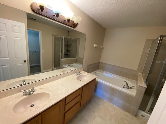 1227 Juniper Hammock St, Winter Garden, FL 34787 - bathroom featuring a shower stall, a bath, a textured ceiling, double vanity, and a walk in closet