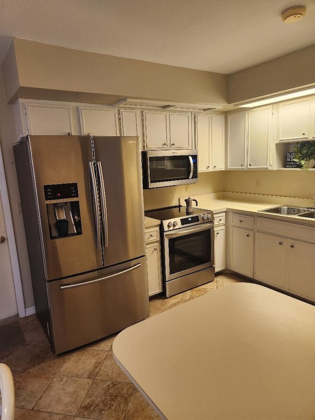 1626 Willow Run, Sebring, FL 33872 - kitchen with appliances with stainless steel finishes, white cabinets, and light countertops