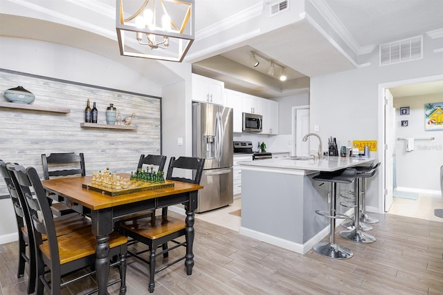 12204 Wild Iris Way Unit 108, Orlando, FL 32837 - dining space featuring light wood finished floors, a chandelier, rail lighting, and crown molding