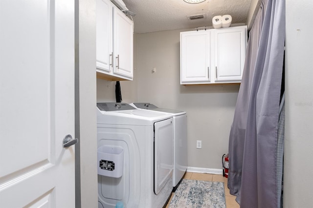 12204 Wild Iris Way Unit 108, Orlando, FL 32837 - washroom featuring cabinet space, washer and dryer, light tile patterned floors, and a textured ceiling