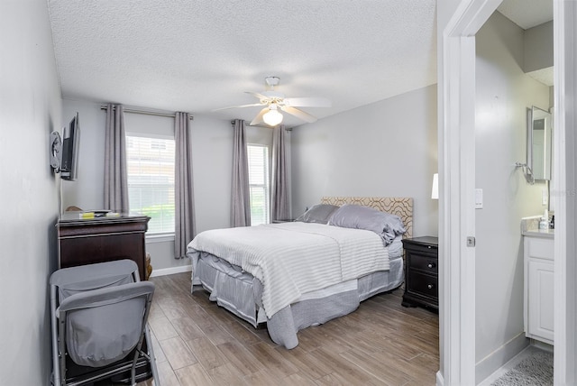 12204 Wild Iris Way Unit 108, Orlando, FL 32837 - bedroom featuring light wood-type flooring, a textured ceiling, and a ceiling fan