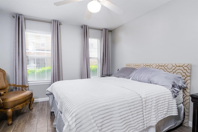 12204 Wild Iris Way Unit 108, Orlando, FL 32837 - bedroom featuring multiple windows, wood finished floors, a textured ceiling, and ceiling fan