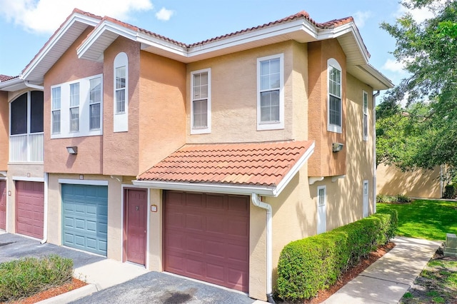 12204 Wild Iris Way Unit 108, Orlando, FL 32837 - view of property featuring stucco siding, an attached garage, a tile roof, and driveway