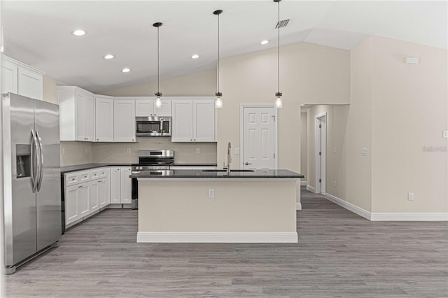 12756 SW 80th St, Dunnellon, FL 34432 - kitchen with appliances with stainless steel finishes, dark countertops, vaulted ceiling, white cabinets, and light wood finished floors