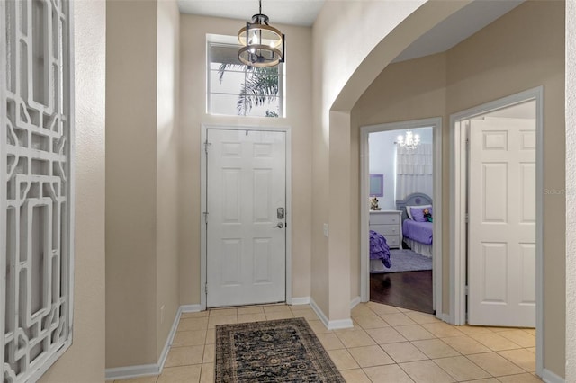 2222 Wyndham Palms Way, Kissimmee, FL 34747 - foyer with a chandelier, light tile patterned flooring, and arched walkways