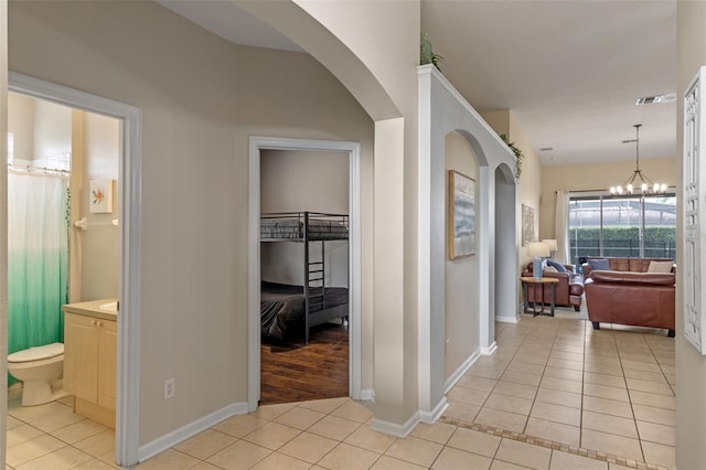 2222 Wyndham Palms Way, Kissimmee, FL 34747 - hall with light tile patterned floors, arched walkways, and a chandelier