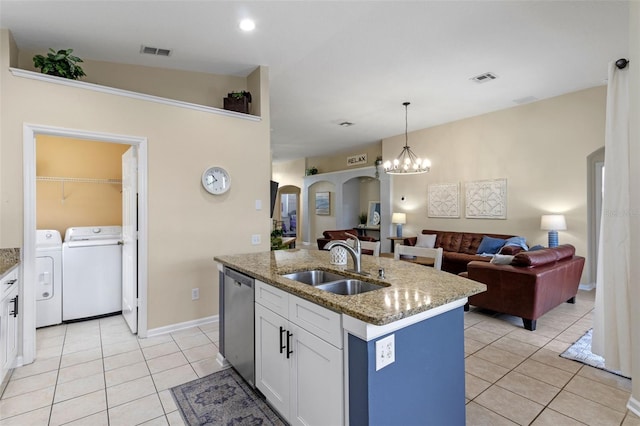 2222 Wyndham Palms Way, Kissimmee, FL 34747 - kitchen with separate washer and dryer, stainless steel dishwasher, light tile patterned flooring, open floor plan, and an island with sink