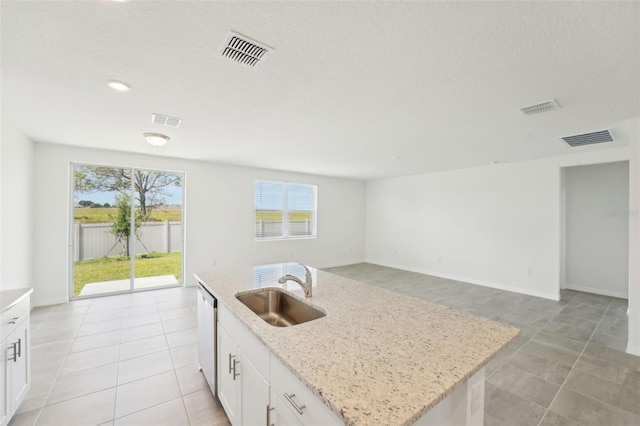 1349 Oak Valley Dr, Auburndale, FL 33823 - kitchen with a kitchen island with sink, light stone counters, stainless steel dishwasher, and white cabinetry