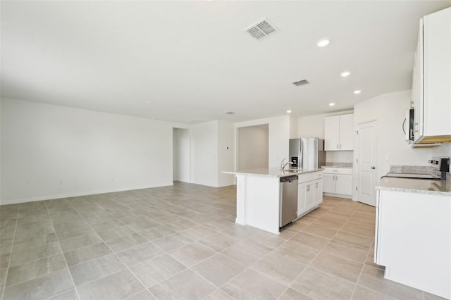 1349 Oak Valley Dr, Auburndale, FL 33823 - kitchen with appliances with stainless steel finishes, a center island with sink, recessed lighting, open floor plan, and white cabinetry