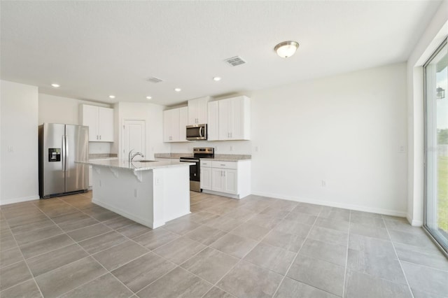 1349 Oak Valley Dr, Auburndale, FL 33823 - kitchen featuring stainless steel appliances, plenty of natural light, a kitchen bar, white cabinetry, and recessed lighting