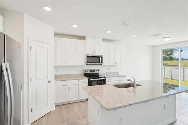 1349 Oak Valley Dr, Auburndale, FL 33823 - kitchen with stainless steel appliances, light tile patterned floors, light stone countertops, white cabinetry, and recessed lighting