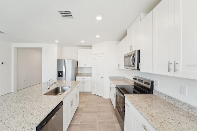 1349 Oak Valley Dr, Auburndale, FL 33823 - kitchen featuring stainless steel appliances, recessed lighting, light stone counters, white cabinets, and light tile patterned flooring