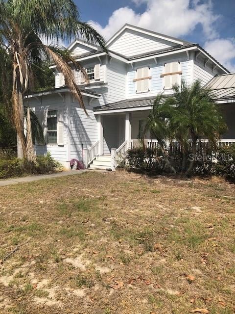 310 W Lake Ave, Auburndale, FL 33823 - view of front facade with a porch and a front yard