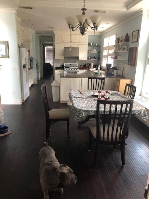 310 W Lake Ave, Auburndale, FL 33823 - dining room with ornamental molding, dark wood-style floors, and a chandelier
