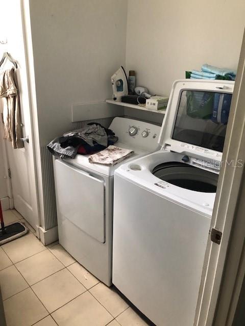 310 W Lake Ave, Auburndale, FL 33823 - laundry area with washing machine and dryer and light tile patterned flooring