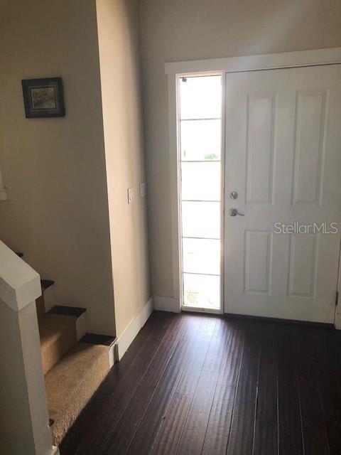 310 W Lake Ave, Auburndale, FL 33823 - entrance foyer with dark wood-style floors and stairway