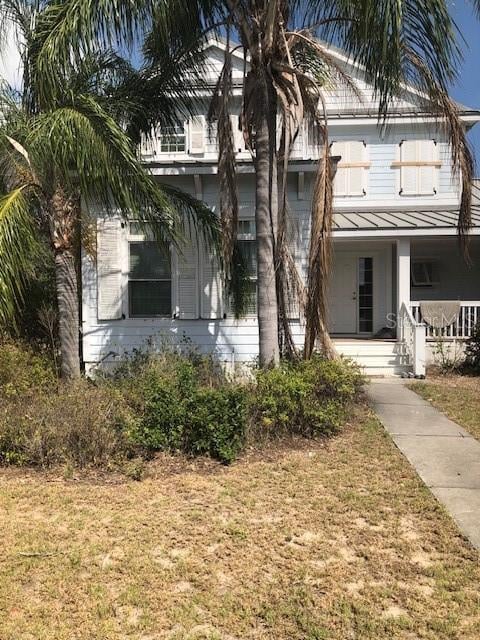 310 W Lake Ave, Auburndale, FL 33823 - obstructed view of property with a standing seam roof, a metal roof, covered porch, and a front yard