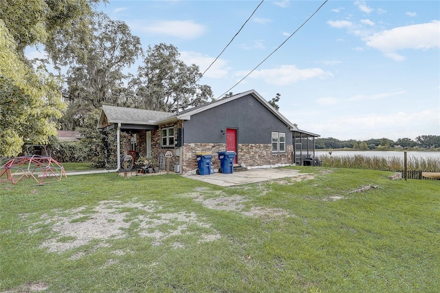 369 Bluff Lake Rd, Mascotte, FL 34753 - rear view of property with a water view, a lawn, stone siding, and a patio
