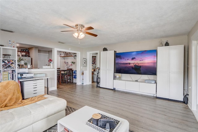 369 Bluff Lake Rd, Mascotte, FL 34753 - living room featuring ceiling fan, light wood finished floors, and a textured ceiling
