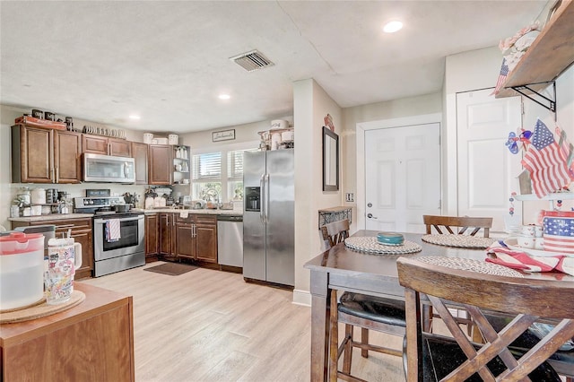 369 Bluff Lake Rd, Mascotte, FL 34753 - kitchen with appliances with stainless steel finishes, light wood-style flooring, open shelves, light countertops, and recessed lighting