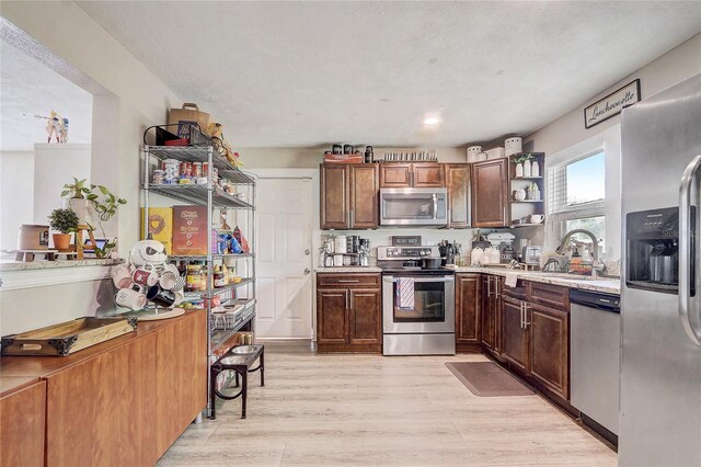 369 Bluff Lake Rd, Mascotte, FL 34753 - kitchen with stainless steel appliances, open shelves, light wood-style flooring, and recessed lighting