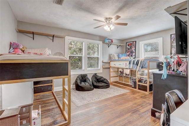369 Bluff Lake Rd, Mascotte, FL 34753 - bedroom featuring wood-type flooring, a textured ceiling, and ceiling fan