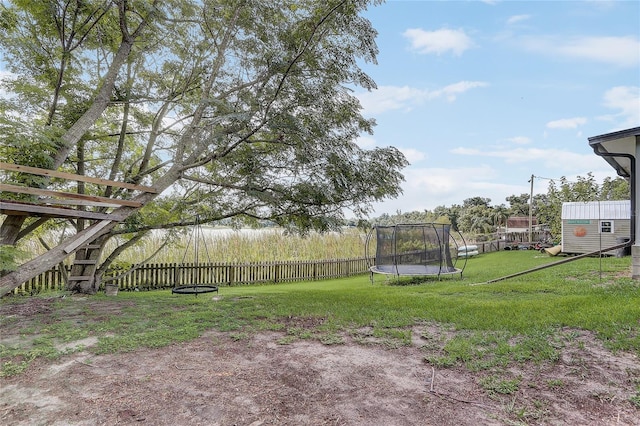 369 Bluff Lake Rd, Mascotte, FL 34753 - fenced backyard with a trampoline and a playground