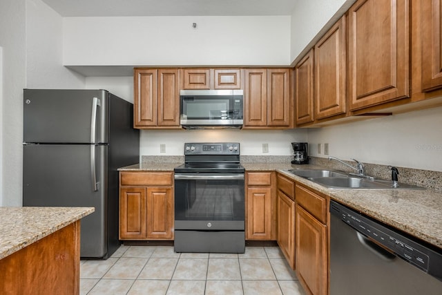 12527 Floridays Resort Dr Unit E104, Orlando, FL 32821 - kitchen featuring stainless steel appliances, brown cabinetry, and light tile patterned flooring