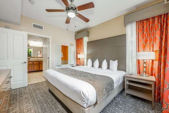 12527 Floridays Resort Dr Unit E104, Orlando, FL 32821 - tiled bedroom featuring connected bathroom and a ceiling fan