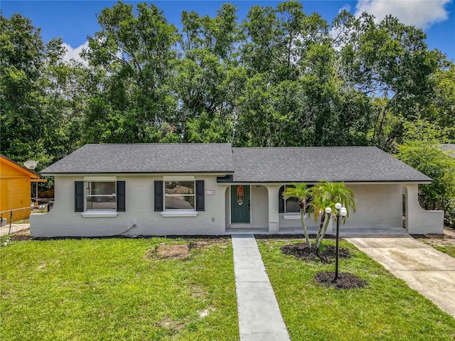 2109 Hartwell Ave, Sanford, FL 32771 - view of front of home featuring concrete driveway, roof with shingles, stucco siding, and a front lawn