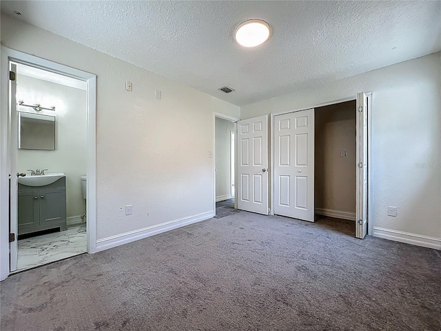 2109 Hartwell Ave, Sanford, FL 32771 - unfurnished bedroom with a textured ceiling, carpet, ensuite bathroom, and a closet
