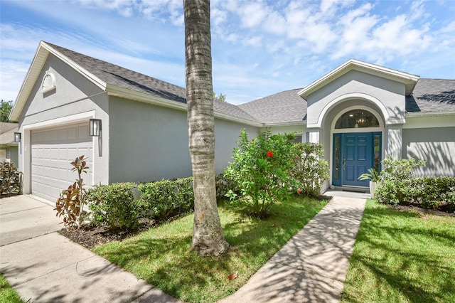 189 Blackstone Creek Rd, Groveland, FL 34736 - view of front of house featuring stucco siding, a garage, a shingled roof, and driveway