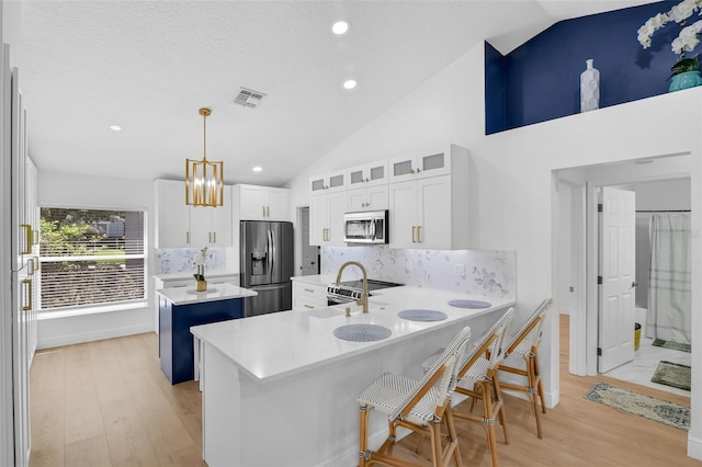 189 Blackstone Creek Rd, Groveland, FL 34736 - kitchen with stainless steel appliances, vaulted ceiling, a kitchen island, a peninsula, and backsplash