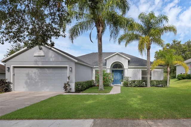 189 Blackstone Creek Rd, Groveland, FL 34736 - ranch-style house featuring stucco siding, an attached garage, a front yard, driveway, and roof with shingles