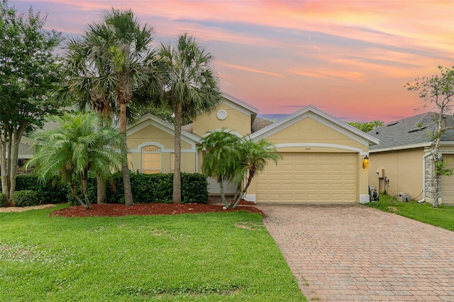 3896 Esplanade Ave, Port Orange, FL 32129 - view of front of house featuring decorative driveway, a front lawn, an attached garage, and stucco siding