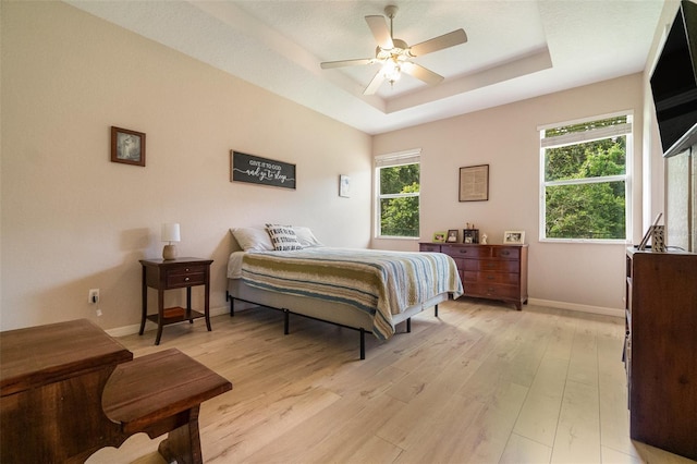 3896 Esplanade Ave, Port Orange, FL 32129 - bedroom with light wood finished floors, a tray ceiling, and ceiling fan