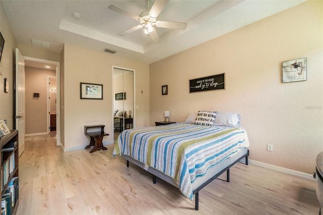 3896 Esplanade Ave, Port Orange, FL 32129 - bedroom featuring a raised ceiling, light wood-style floors, a closet, and ceiling fan