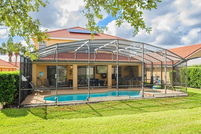 1428 Solana Cir, Davenport, FL 33897 - rear view of house with a tile roof, glass enclosure, a patio area, a lawn, and stucco siding