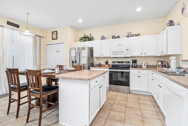 1428 Solana Cir, Davenport, FL 33897 - kitchen featuring stainless steel appliances, a center island, light countertops, white cabinets, and light tile patterned flooring